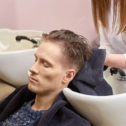 Coiffeur réalisant une coupe homme au salon